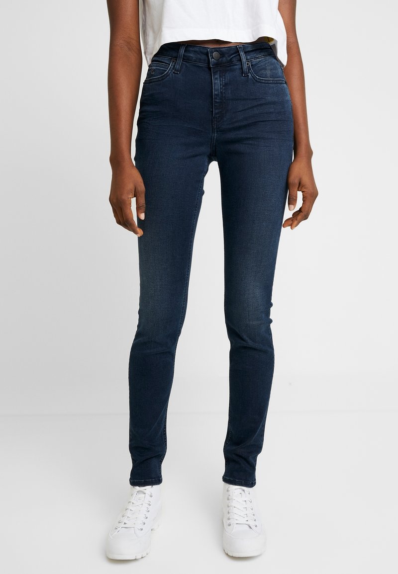 Tmavě modré vysoké skinny džíny z denimu, s hladkým povrchem, klasickým pětikolíkovým designem a zapínáním na knoflík.