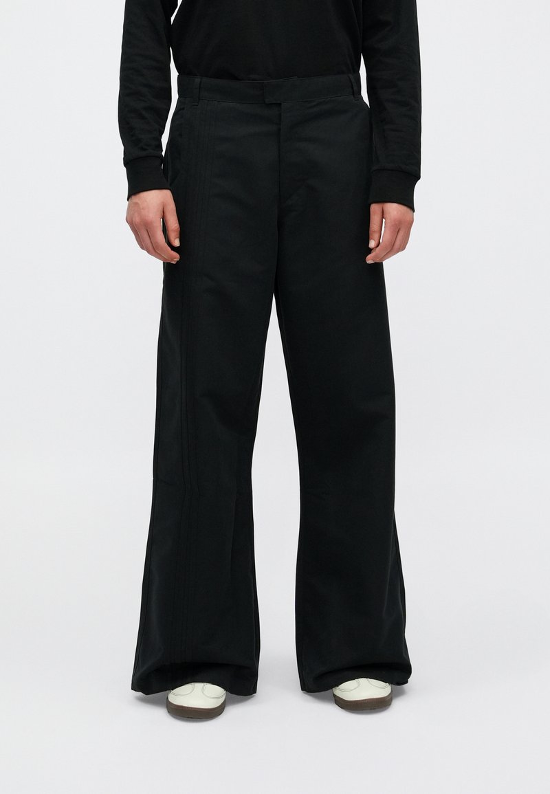 Zwarte wijde broek van katoenmix, met een gladde textuur, twee voorzakken en subtiele verticale stiksels.