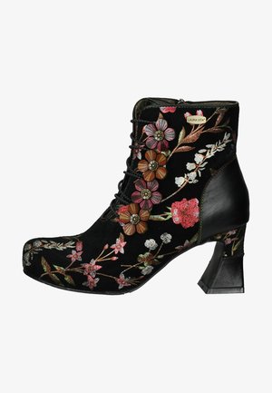 Bottine en daim noir avec broderies florales dans des teintes de rose, rouge et blanc. Elle présente un laçage à l'avant et un talon bloc.