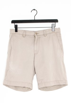 Beżowe bawełniane szorty z płaskim przodem, zapięciem na guzik i zamek, dwoma bocznymi kieszeniami oraz podwiniętymi mankietami na dole.