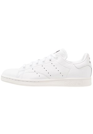 Hvid Adidas Stan Smith sneaker med lavskaftet snørestil, perforerede striber på siden, tekstureret læder samt mærket sål og hællap.