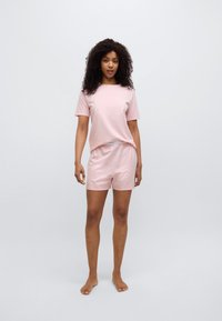 Σετ από ανοιχτό ροζ κοντομάνικο βαμβακερό μπλουζάκι και σορτς. Το μπλουζάκι έχει στρογγυλή λαιμόκοψη, ενώ το σορτς διαθέτει ελαστική μέση.