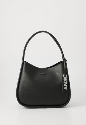 Sac à main en cuir noir texturé avec une bandoulière unique, bord supérieur incurvé et une étiquette suspendue avec des lettres DKNY argentées.