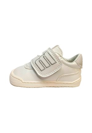 Zapatilla blanca para niño pequeño con una sola tira ancha de velcro y costuras con textura, mostrada de perfil izquierdo sobre un fondo liso.
