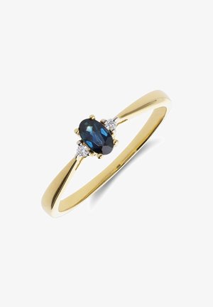 Gouden ring met een ovale blauwe saffier als centrale steen, geflankeerd door twee kleine ronde diamanten op een witte achtergrond.