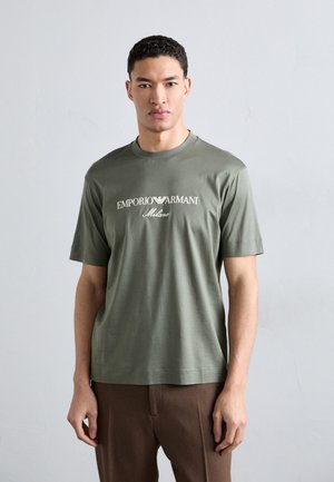 Olive green cotton t-shirt with short sleeves and round neck; features "EMPORIO ARMANI Milano" logo in white across the chest.