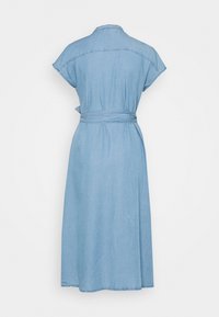 Robe midi en denim bleu clair avec manches courtes, col et ceinture à nouer à la taille, vue de dos sur fond blanc.