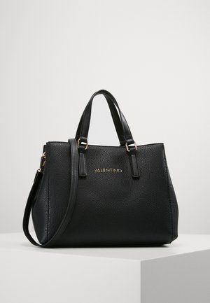 Sac à main en cuir noir à texture granuleuse avec deux poignées supérieures, une bandoulière amovible et un logo doré en relief. Forme arrondie, design minimaliste.
