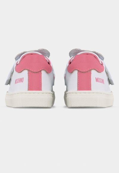 Λευκά και ροζ αθλητικά παπούτσια χαμηλού προφίλ, που φαίνονται από πίσω, με ροζ ταμπελάκια στη φτέρνα και το σήμα "Moschino" στις εξωτερικές πλευρές.