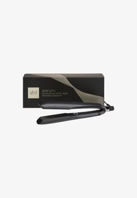 Zwarte ghd Platinum+ professionele slimme haarstyler met verwarmde platen, geplaatst voor zijn zwarte en gouden doosverpakking.