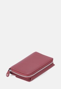 Röd läderplånbok med texturerad yta, med en vit dragkedjestängning och en slimmad profil. Kompakt rektangulär form.