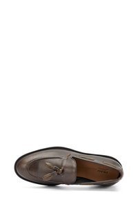 Mocassin en cuir marron avec un accent de gland, des lignes épurées et une couture contrastée le long des bords pour une touche de détail supplémentaire.