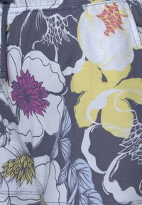 Grijze stof met een bloemmotief met gele, paarse en witte bloemen. Inclusief groene bladeren en fijne details in het ontwerp.