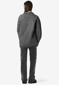 Mustmustest must-libisemiseks jakku ja sobivaid pükse, millel on mugav lõige. Jakil on klassikaline kaelus ja nähtavad õmbluse detailid.