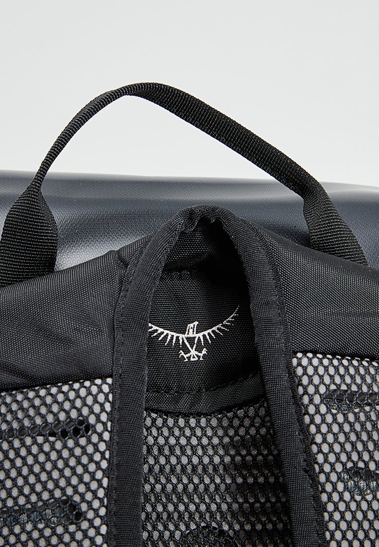 Sac à dos noir avec des détails en mesh, une poignée supérieure et un graphisme de logo. Le matériau semble durable avec un design structuré.