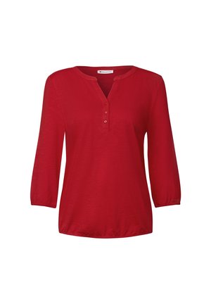 Blusa rossa a maniche lunghe con scollatura a V e tre bottoni sul collo. Tessuto leggero, maniche leggermente arricciate e vestibilità rilassata.