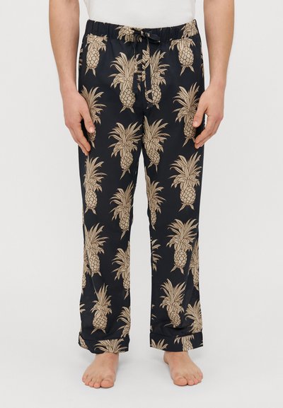Pantalones de pijama negros con un patrón de piñas crema, cinturilla elástica y cordón. Corte relajado con piernas rectas y dobladillos ajustados.