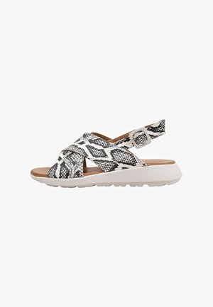 Sandales imprimées serpent noir et blanc avec un design à brides croisées, talon ouvert et boucle réglable. Dotées d'une semelle texturée pour une meilleure adhérence.