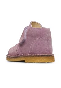 Scarpa per bambino in suede viola singolo con cinturino in velcro e suola in crepe marrone chiaro, vista dal lato destro posteriore.