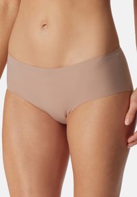 Beige bikinityylinen alusvaate, jossa on sileä pinta, keskipitkä vyötärö ja saumatonta muotoilua mukavuutta varten. Ominaisuuksina tasainen, yksivärinen pinta.