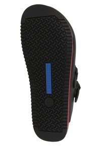Schwarze Gummisohlen mit einem wellenförmigen, strukturierten Muster. Blaues "Birkenstock"-Logo und roter Akzent an der Seite. Größenmarkierungen sichtbar.