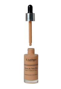 Strahlendes Teint-Serum in einer klaren Glasflasche mit einem silbernen Deckel und schwarzem Tropfer. Die Flüssigkeit im Inneren hat einen hellbeigen Farbton.