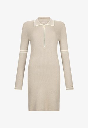 Beige ribbet kjole med lynlås i kraven, lange ærmer og hvide accentstriber. Har en tætsiddende silhuet og logo detaljer nær kanten.