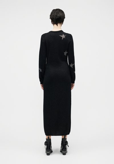 Černé šaty-pulovr s dlouhým rukávem, zdobené stříbrnými hvězdičkami, zaoblený výstřih, přiléhavý střih a strukturovaný pletený povrch.