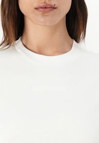Witte katoenen t-shirt met een ronde halslijn, voorzien van een subtiel, blindgeperst "Calvin Klein" logo aan de voorkant. Gladde textuur.
