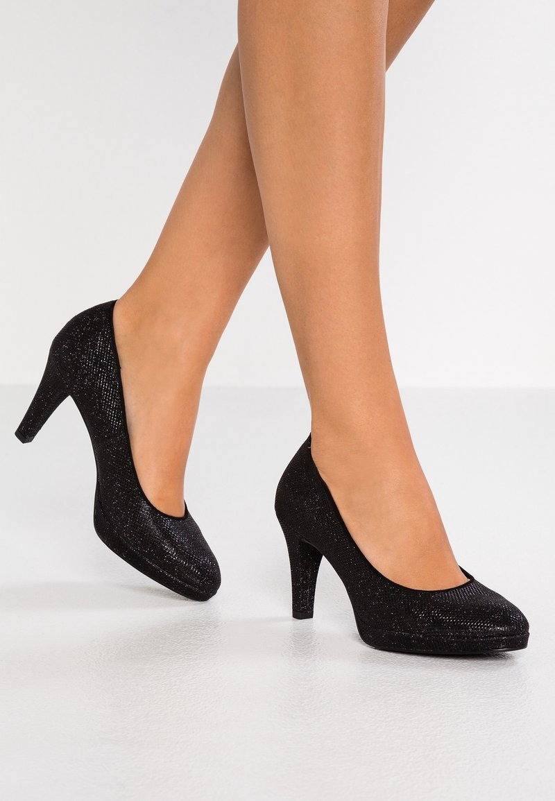 Chaussures à talons hauts noires, texturées, avec un bout arrondi et un talon de 7 cm. La tige présente une surface légèrement scintillante.