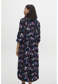 Robe noire à fleurs avec des fleurs colorées en rose, bleu et blanc. Manches longues, taille froncée et longueur mi-mollet. Tissu doux.