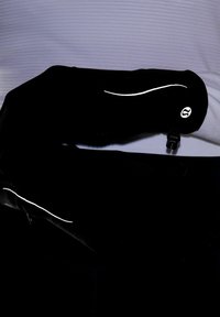 Fekete sportos karhosszabbítók fényvisszaverő részletekkel és texturált anyaggal, biztos rögzítőpánttal a megfelelő illeszkedés érdekében, világos háttér előtt elhelyezve.
