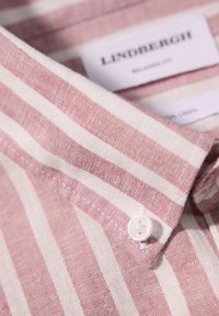 Camicia in cotone-lino leggermente strutturata con righe rosa e bianche, dotata di colletto a punta e dettagli in bianco sui bottoni. Etichetta del marchio visibile.