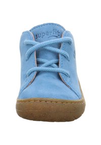 Hellblaue Wildlederschuhe mit brauner Gummisohle, klassisches Schnürdesign und gestickte Details entlang der Kanten.