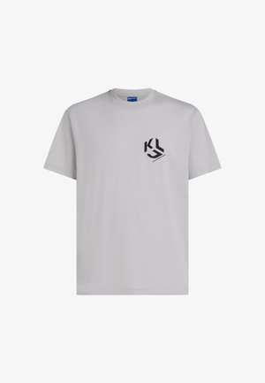 Vaaleanharmaa pyöreäkauluksinen T-paita, jossa on lyhyet hihat ja vasemmassa rintakehässä pieni musta "KL"-logo.