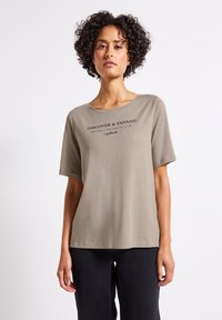 Olivgrön t-shirt med kort ärm och rund halsringning, med svart texttryck fram. Mjuk tygkvalitet med en avslappnad passform.