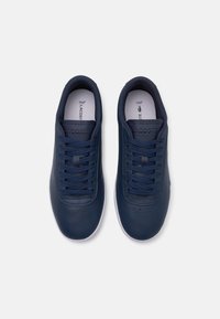 Navy blue leather sneakers with lace-up design, perforated detailing on the toe, and white rubber soles. Lacoste logo on the tongue.