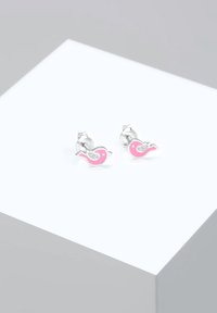 Pendientes de studs en forma de pájaro rosa con respaldo de metal plateado y acentos de purpurina. Textura suave, diseño juguetón, aptos para un estilo casual.