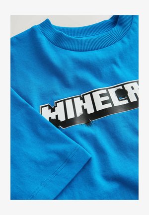 Svijetloplava majica dugih rukava s rebrastim izrezom okruglog vrata i djelomično vidljivim odvažnim bijelim i crnim Minecraft logotipom na prsima.