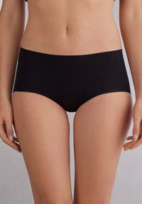 Černé strečové hipster kalhotky s hladkým pasem, minimálními švy a elegantním designem. Vyrobené z měkké, prodyšné látky.