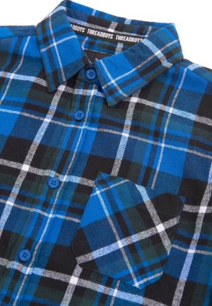 Kariertes Hemd in Blau, Schwarz und Weiß, mit einem knöpfbaren Kragen, zwei blauen Knöpfen und einer aufgesetzten Tasche aus strukturiertem Stoff.