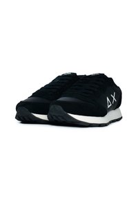 Scarpe sportive nere con una tomaia in suede e mesh, caratterizzate da una suola bianca, lacci texturizzati e un logo argentato sul lato.