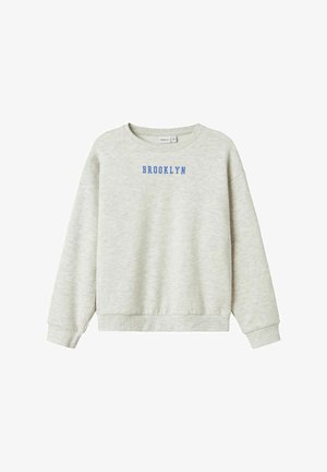 Svetlo siva trenirka z dolgimi rokavi, z rebrastimi manšeti in spodnjim robom, z napisom "BROOKLYN" v modrih velikih črkah na prsih.