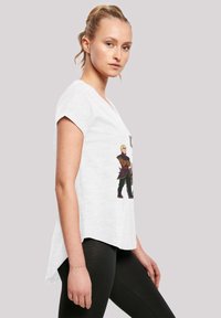 Vit kortärmad T-shirt med rundad fåll, med en färgglad grafiktryck på framsidan av två animerade karaktärer.