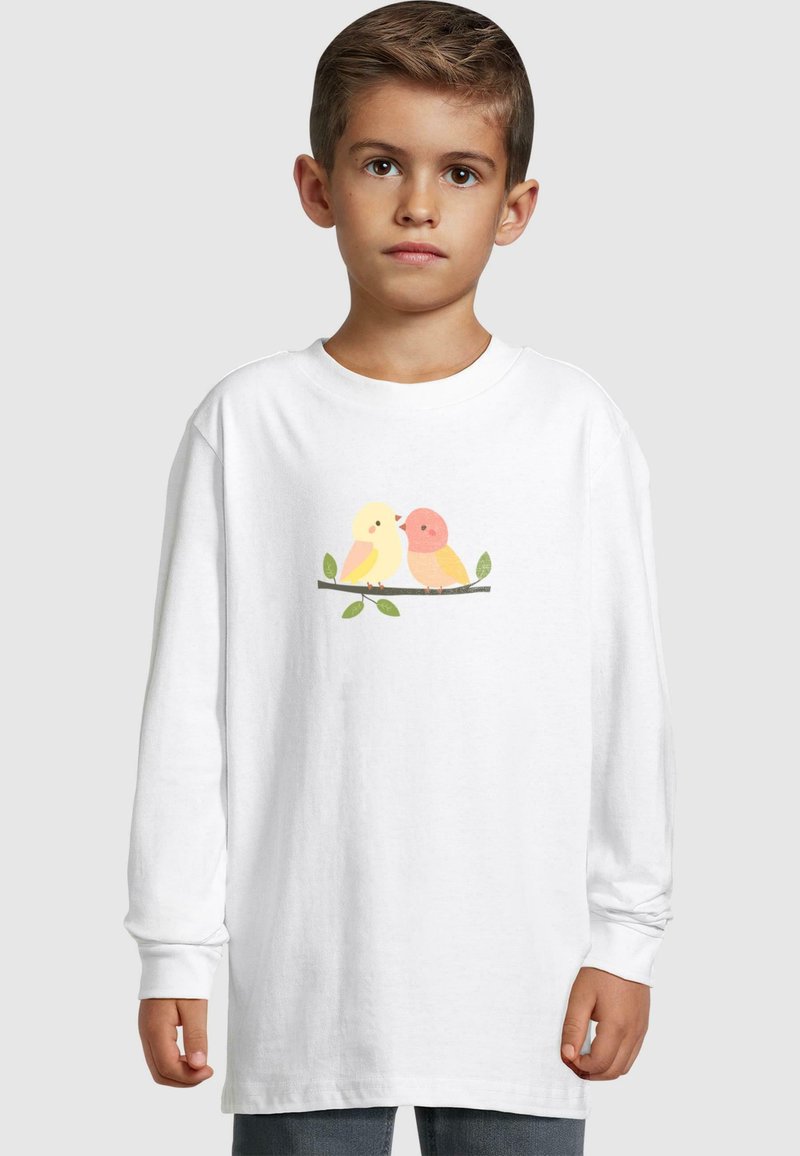 White long-sleeve t-shirt features a graphic of two colorful cartoon birds on a branch with green leaves. Soft cotton fabric, relaxed fit.