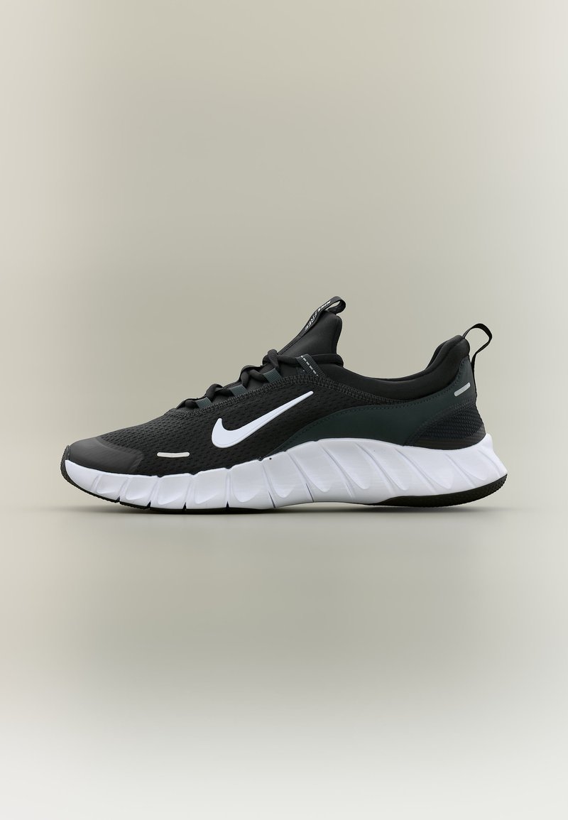 Μαύρο αθλητικό παπούτσι Nike με λευκό λογότυπο Swoosh και παχύ λευκό πέλμα, εμφανιζόμενο σε ανοιχτό ουδέτερο φόντο, πλευρική όψη.