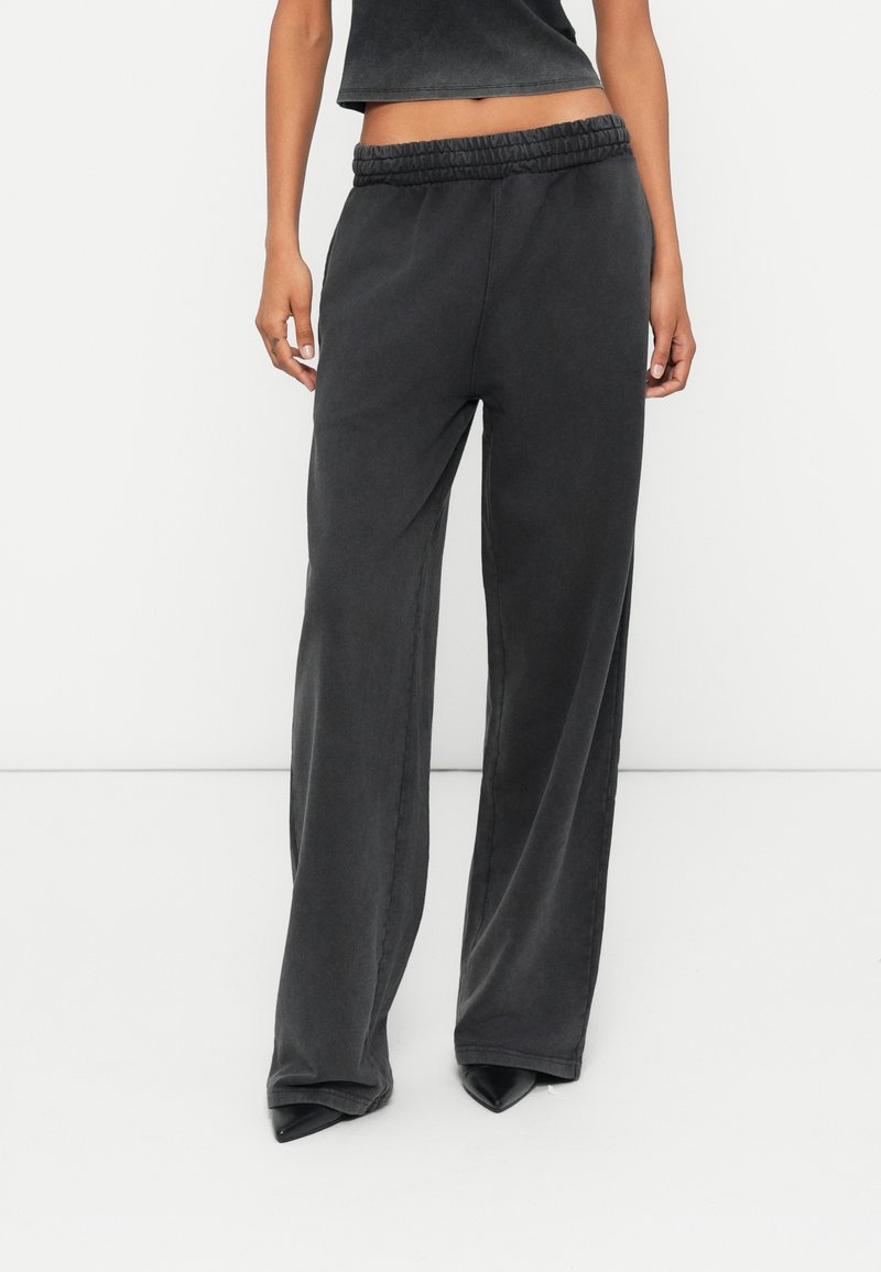 Charcoalgrijze wijde pantalon met een elastische tailleband. Zachte stof met een gladde textuur, voorzien van naden in de zijkanten en zakken.