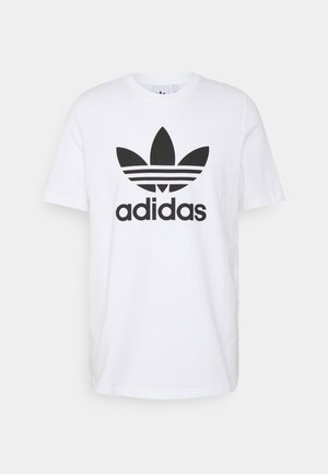 Biała bawełniana koszulka z krótkimi rękawami, z czarnym logo Adidas i trzema paskami powyżej logo, standardowy dekolt typu crew neck.