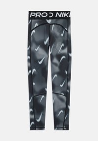 Crne i sive Nike tajice s raspršenim bijelim uzorkom swoosh te crnim pojasom s djelomičnim bijelim tekstom "PRO NIK".