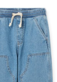 Lichtblauwe denim broek met een elastische tailleband en een trekkoord. Beschikt over twee voorzakken en zichtbare stikseldetails.